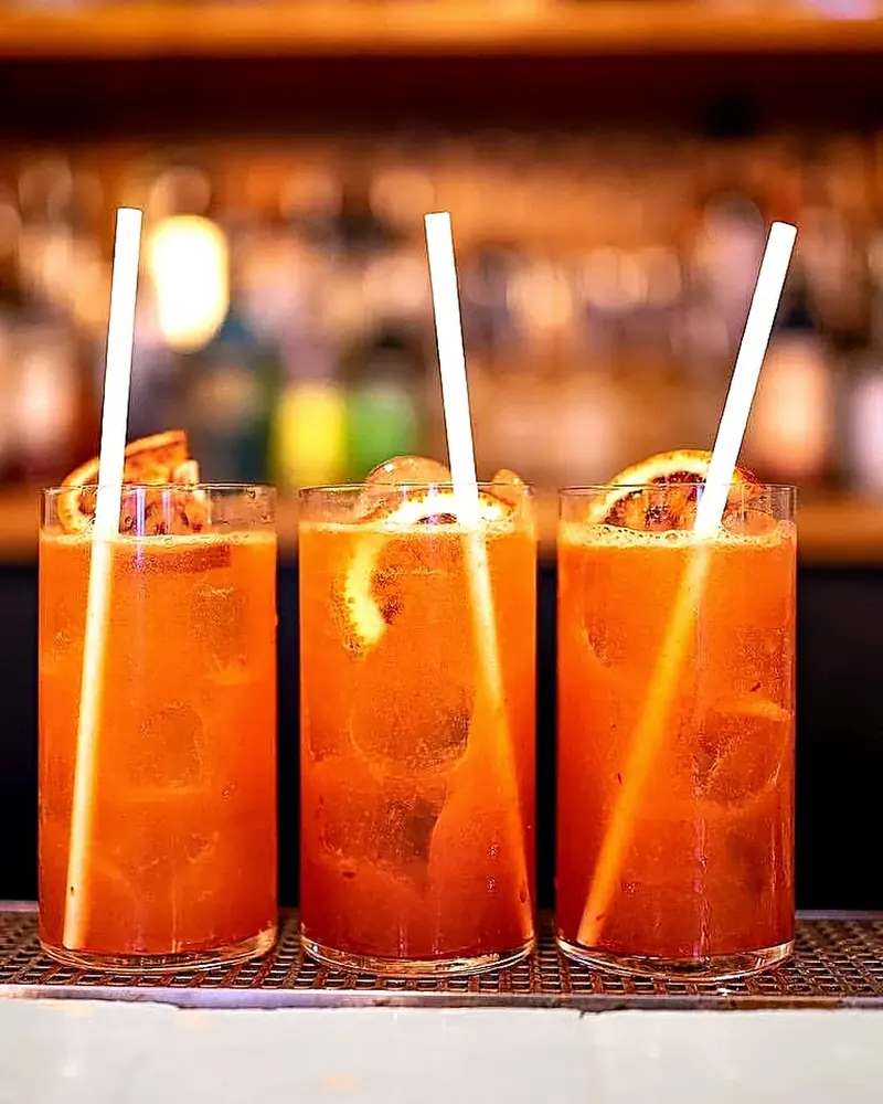 Trois cocktails servis sur le comptoir du Phantom, bouteilles en arrière-plan